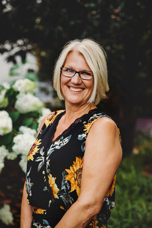 Smiling woman in floral top outdoors garden