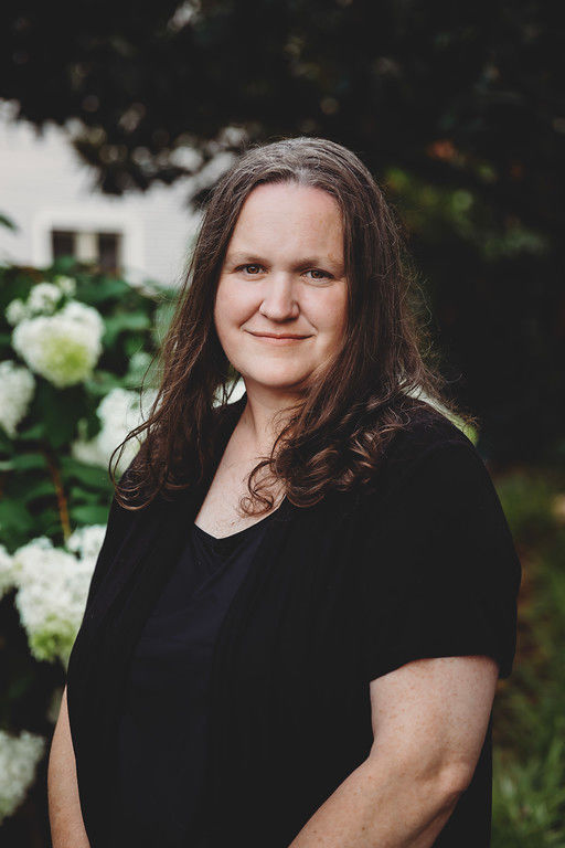 Woman standing in garden with white flowers