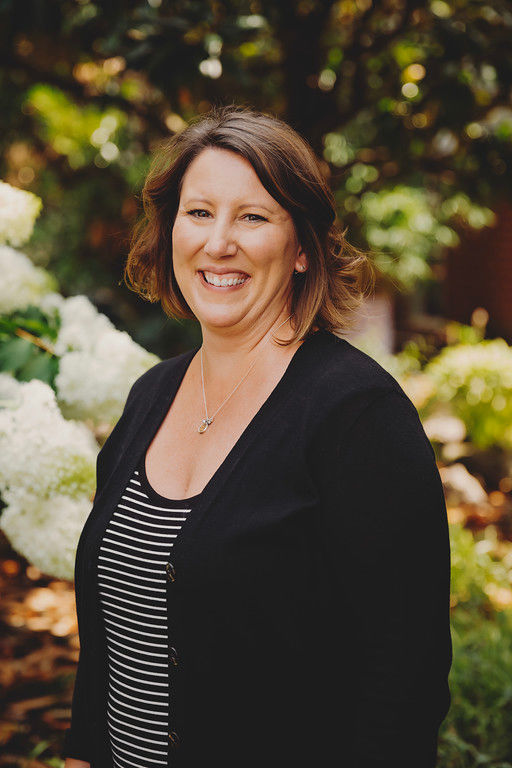 Smiling woman in garden with white flowers