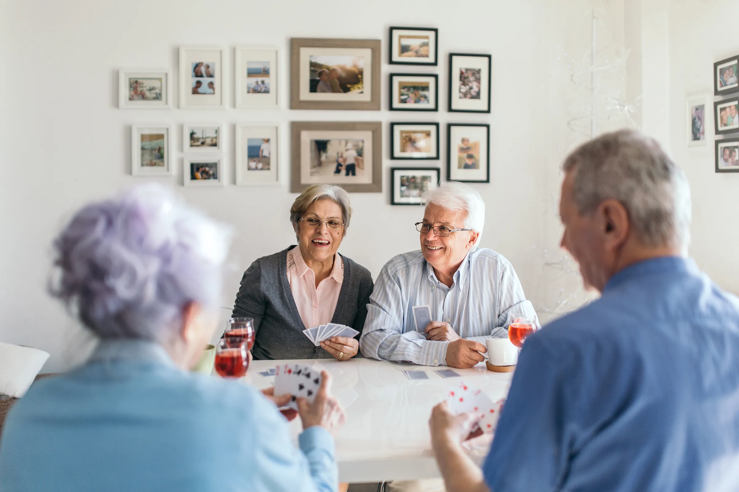 Senior friends playing cards at dining table