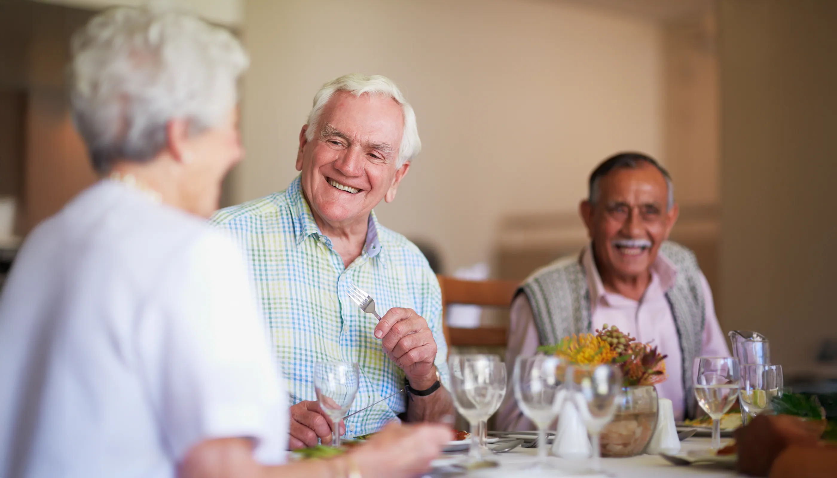 Senior friends enjoying dinner together at table
